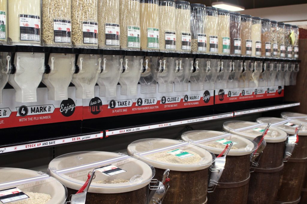 row of wooden barrels and bulk dispensers filled with bulk grocery items.